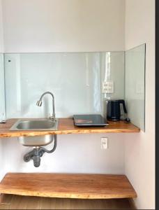 a kitchen with a sink and a counter with a mirror at MIDMOST CASA in Can Tho