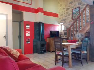 een woonkamer met een tafel en een bank bij Gîte le MAGNAN, 55 m2, havre de paix, terrasse, jardin, piscine chauffée, sud Ardèche in Joyeuse