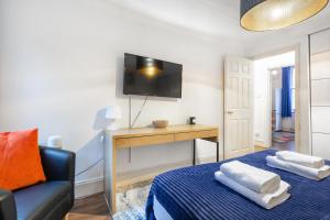 1 dormitorio con 1 cama, TV y silla en Lovely One Bed in the Heart of Covent Garden, en Londres