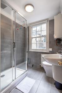 y baño con ducha, aseo y lavamanos. en Lovely One Bed in the Heart of Covent Garden, en Londres