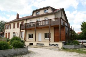 an old house with a balcony on the side of it at Chambres d'hôtes & Gîtes La Paysanne in Fresnes-en-Woëvre