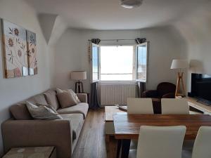 - un salon avec un canapé et une table dans l'établissement Au gré des marées 2 appartement face à la mer 2ème étage, à Ault