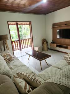 ein Wohnzimmer mit einem Sofa und einem Couchtisch in der Unterkunft Hospedagem Vanilda in Nova Friburgo