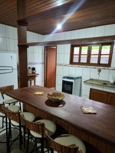 una cocina con una gran mesa de madera y sillas en Hospedagem Vanilda, en Nova Friburgo