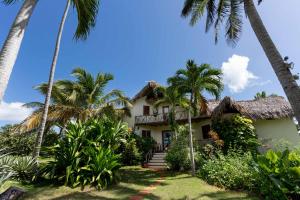 a house on the beach with palm trees at Villa Punta Coral in Las Galeras