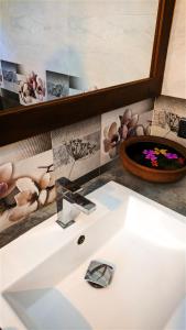 ein Badezimmer mit einem weißen Waschbecken und einem Spiegel in der Unterkunft Hilltop House in Arugam Bay