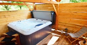 a jacuzzi tub on a wooden deck at Roulotte - Etat Nature in Magnières