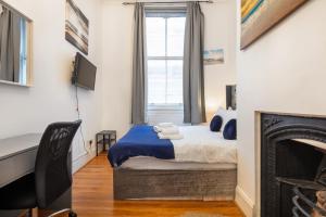 a bedroom with a bed and a fireplace at DELUXE Two Bed in Covent Garden in London