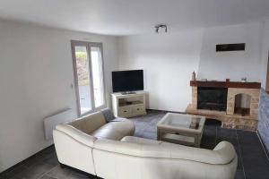 a living room with a white couch and a fireplace at Pavillon 3 chambres avec piscine, Garat (16) in Garat