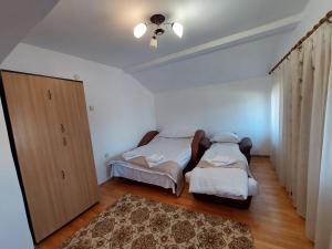 a bedroom with two beds and a closet at Casa Auraș 