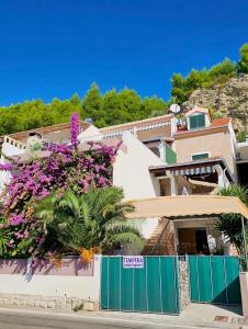 a house with purple flowers on the side of it at Apartments Tempera by the beach in Split