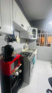 cocina con fogones y horno rojo en HOSTAL Letys Place Emilio, en Ciudad de México