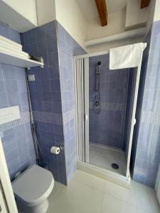 e bagno piastrellato blu con doccia e servizi igienici. di Palazzo di Fazio Suites a San Severo