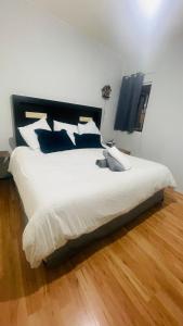 Un dormitorio con una gran cama blanca con almohadas azules. en HOSTAL Letys Place Emilio, en Ciudad de México