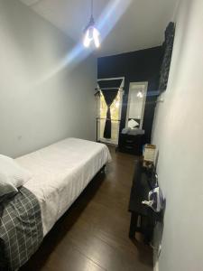 Dormitorio pequeño con cama y espejo en HOSTAL Letys Place Emilio, en Ciudad de México