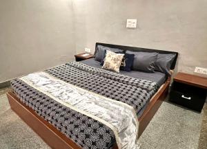 a bedroom with a large bed with blue pillows at Room with attach washroom on main road- Rajiv Chowk Gurgaon in Gurgaon