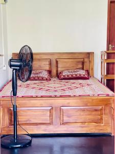 a bedroom with a wooden bed with a fan at Lucky Lodge in Koggala