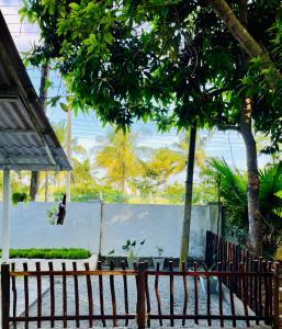 a fence in front of a yard with trees at Lucky Lodge in Koggala