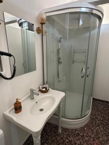 ein weißes Bad mit einer Dusche und einem Waschbecken in der Unterkunft Kensington Prince's Island Historical Mansion in Adalar