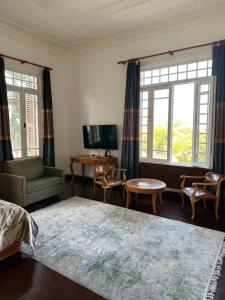 a living room with a bed and chairs and windows at Kensington Prince's Island Historical Mansion in Adalar