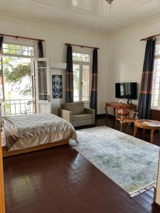 um quarto com uma cama e uma sala de estar em Kensington Prince's Island Historical Mansion em Adalar