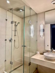 La salle de bains est pourvue d'une douche en verre et d'un lavabo. dans l'établissement Apart luxe, à Casablanca