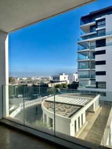 uma vista a partir da varanda de um edifício com uma grande janela em Apart luxe em Casablanca