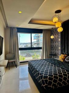 - une chambre avec un lit et une grande fenêtre dans l'établissement Apart luxe, à Casablanca