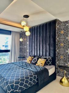 - une chambre avec un lit bleu et une tête de lit noire dans l'établissement Apart luxe, à Casablanca