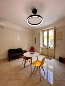 ein Wohnzimmer mit einem Tisch, Stühlen und einem Sofa in der Unterkunft Casa Dom-Ino 25 in Bagheria