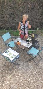 una donna in piedi davanti a un tavolo con del cibo di 1 Chambre double "Le Devenir" a Saint-Julien-les-Villas