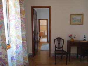 przedpokój z krzesłem, stołem i lustrem w obiekcie Casa da Villa 1B w mieście Sintra