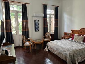 Kensington Prince's Island Historical Mansion في جزر الأمراء: غرفة نوم بسرير وطاولة وكراسي