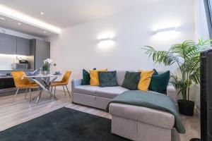 a living room with a couch and a table at elegant apartment 3 in Milton Keynes