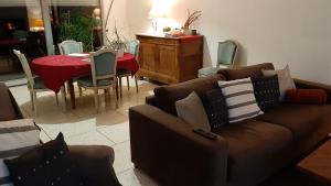 un salon avec un canapé et une table ainsi qu'une salle à manger dans l'établissement 1 Chambre double "Le Devenir", à Saint-Julien-les-Villas