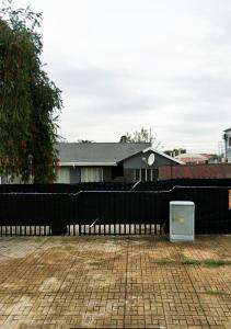 Ein schwarzer Zaun vor einem Haus in der Unterkunft NSK GUEST HOUSE in Alberton