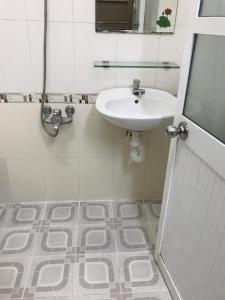 La salle de bains blanche est pourvue d'un lavabo et d'un miroir. dans l'établissement Lucky Home, à Nha Trang