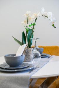 una mesa con placas azules y un jarrón con flores blancas en elegant apartment 3 en Milton Keynes