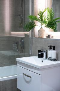 a bathroom with a white sink and a shower at elegant apartment 3 in Milton Keynes