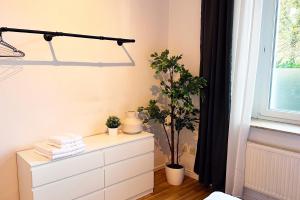a bedroom with a dresser and a window at Modernes City-Apartment nahe Messe Düsseldorf in Krefeld