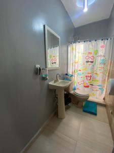 baño con lavabo y aseo con cortina de ducha en HOSTAL Letys Place Emilio, en Ciudad de México