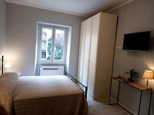 a bedroom with a bed and a cabinet and a window at Casa Paolina a Metro San Paolo in Rome