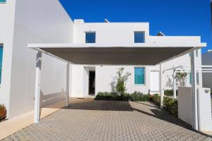 a white building with awning in front of it at Villa Central By Garvetur in Quarteira
