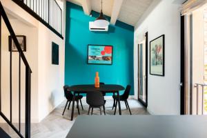 a dining room with a blue wall at Piazza Savonarola 13 in Imola