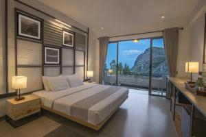 a bedroom with a large bed and a large window at Hotel Onrock in Ella