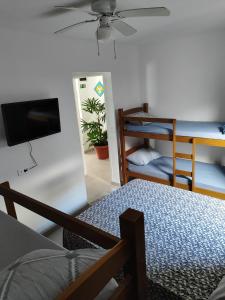 瓜魯雅的住宿－Pousada Sol da Manhã，客房设有带一张床和电视的卧室。