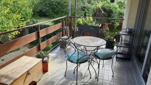 eine Terrasse mit einem Tisch und Stühlen auf dem Balkon in der Unterkunft 1 Chambre double "Le Devenir" in Saint-Julien-les-Villas