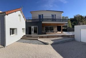 a large white house with a balcony on top of it at Villa Saint Romain au cœur de l Auvergne in Mirefleurs