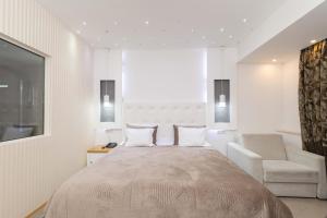 ein Schlafzimmer mit einem Bett, einem Stuhl und einem Fenster in der Unterkunft Gardenia Hotel & Spa in Veles
