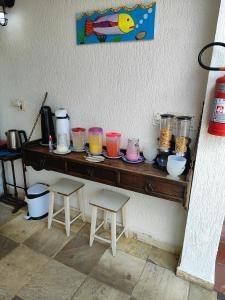 una mesa con muchos tarros de colores diferentes en ella en Pousada Sol da Manhã en Guarujá